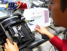 Vacuum repair technician servicing internal components on a workbench in San Jose, CA